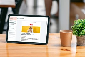 Newsletter Tablet auf dem die Anmeldung zu einem Newsletter zu sehen ist steht auf einem Tisch.