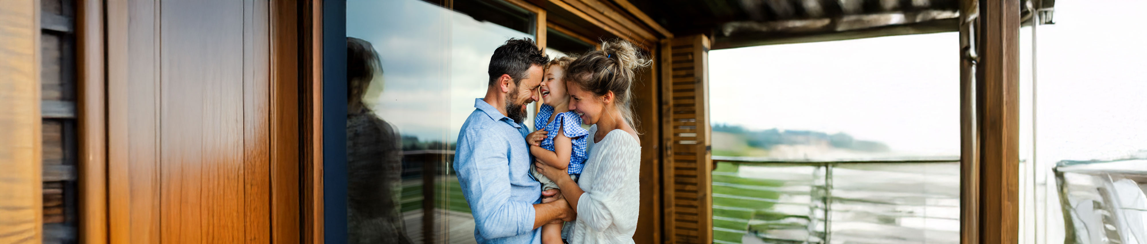 Family with small daughter standing on patio of wooden cabin, holiday in nature concept. Family with small daughter standing on patio of wooden cabin, holiday in nature concept.